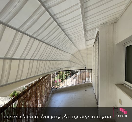 מרפסת עם סוכך לבן מעל מעקה עץ